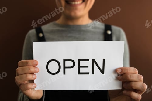Preview: Woman with OPEN sign on brown background