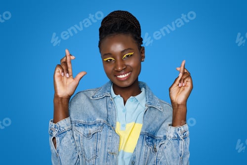 Preview: Smiling pretty bright young african woman with fingers crossed