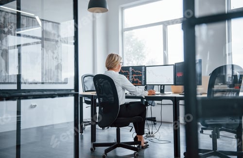 Preview: Female stockbroker in formal clothes works in the office with financial market