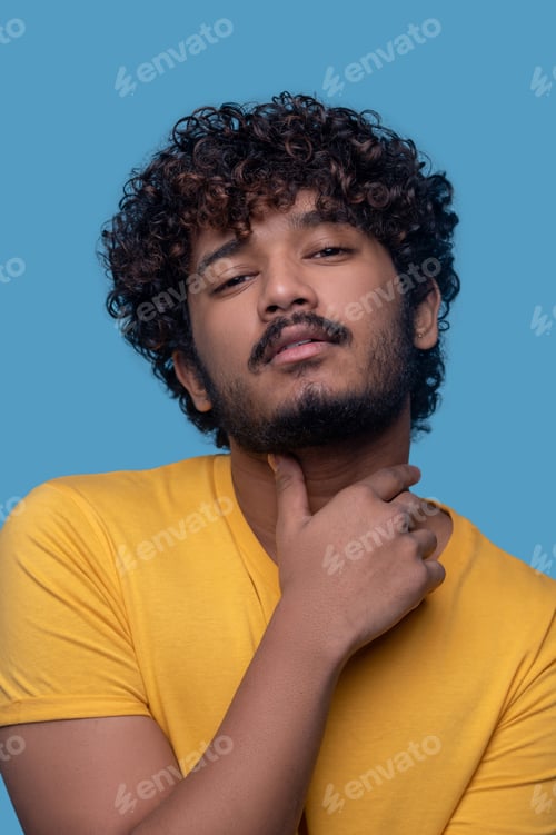 Preview: Tranquil bearded curly-haired attractive guy posing for the camera