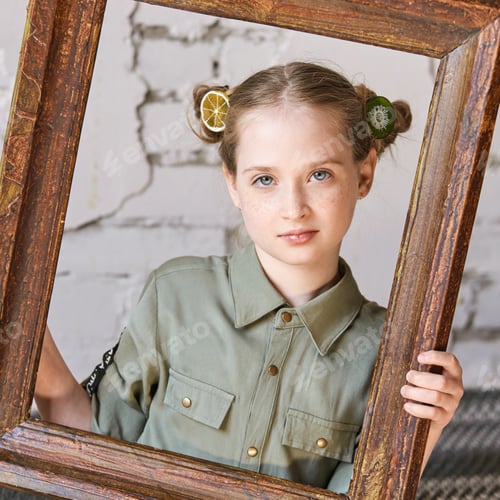Preview: Blonde caucasian young girl with hair buns framed by wooden picture frame