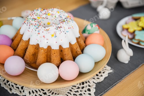 Preview: Easter cake and colorful painted eggs on plate at home