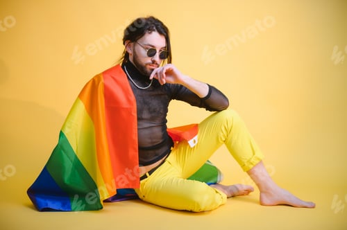 Preview: Gay man hold rainbow striped flag isolated on colored background studio portrait.