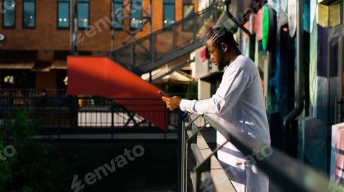 Preview: Millennial generation african american man typing sms outdoor 5g internet concept. High speed