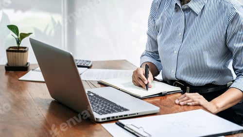 Preview: Professional Man Writing in Notebook with Laptop