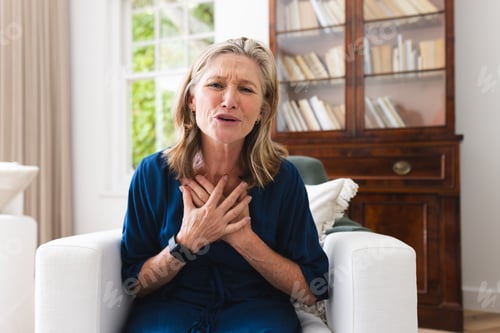 Preview: A caucasian senior female on video call at home, touching her chest