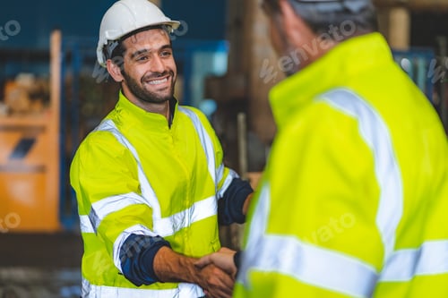 Preview: Caucasian factory engineer talking and shaking hands on business cooperation agreement