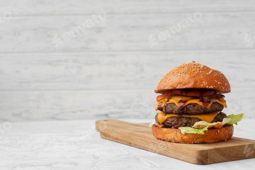 Preview: Double cheeseburger served on wooden board against white blurred background