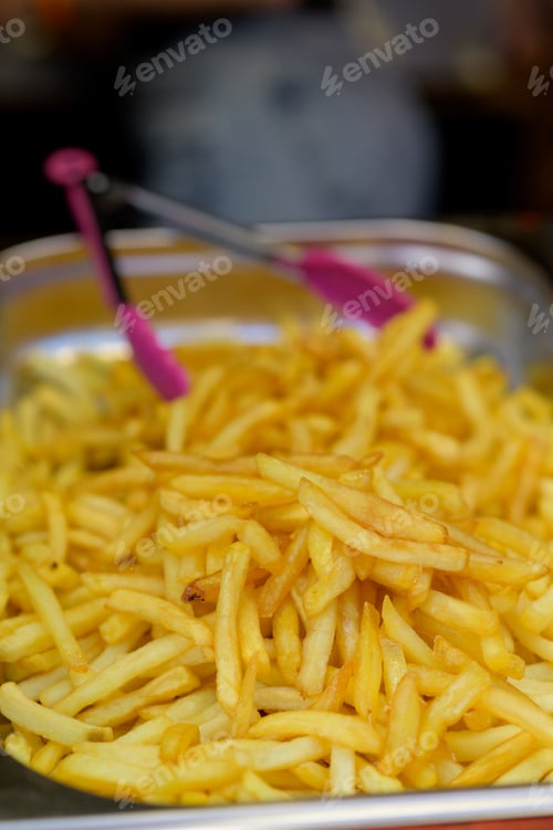 Preview: Overhead view of golden deep fried French fries food in full frame closeup.