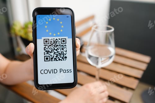 Preview: Woman demonstrates Covid pass application or digital health passport with QR code and USA flag in