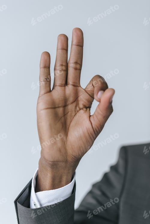 Preview: cropped shot of african american businessman showing ok sign isolated on grey