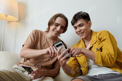 Preview: Young Men Discussing New Mobile App