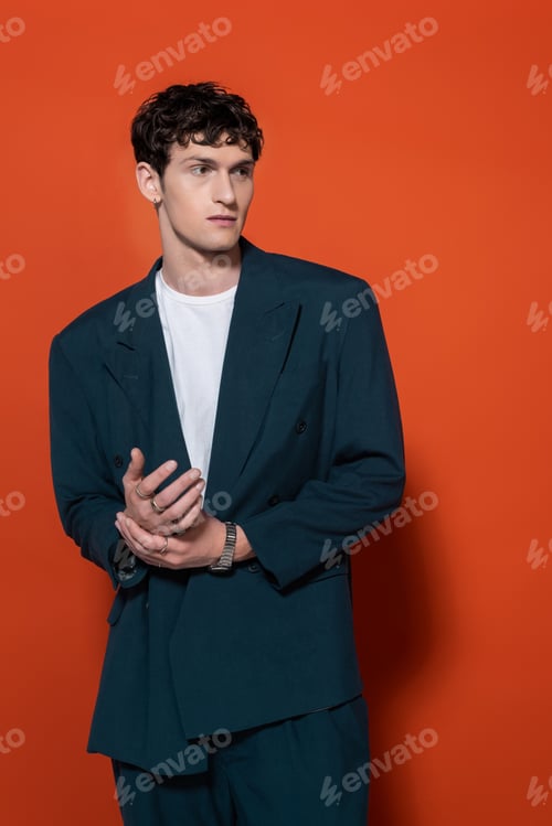 Preview: Brunette man in stylish blue suit posing on red background