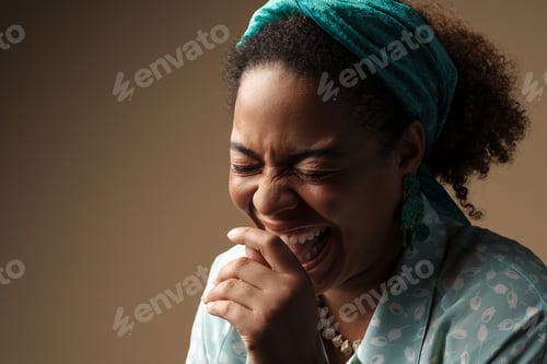 Preview: Young black woman in headband laughing with eyes closed
