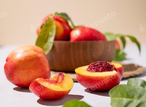 Preview: Juicy and sweet nectarines in a bowl on a light background close up. Healthy organic farm fruit