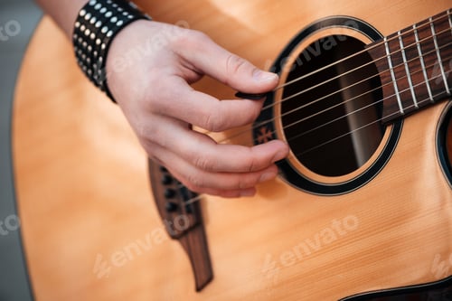 Preview: Male hands playing on guitar outdoors