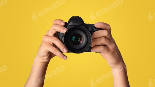 Vista previa: Closeup of photographer pointing DSLR camera at screen, blue background. Panorama