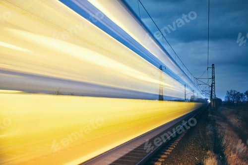 Preview: Railroad track at night. Light trails of passenger train.