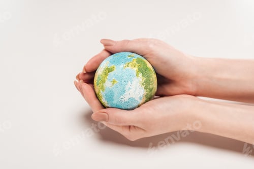 Preview: cropped view of woman holding earth model on white background, global warming concept