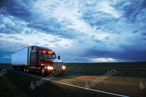 Preview: 3/4 front view of a commercial truck on the road in the early evening in eastern Washington, USA.