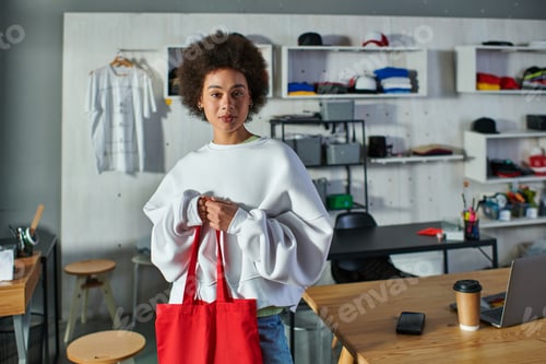 Preview: Young Woman Holding a Red Tote Bag Indoors