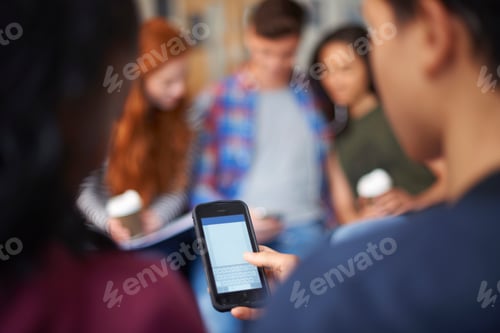 Preview: Young male and female students reading smartphone texts in common room