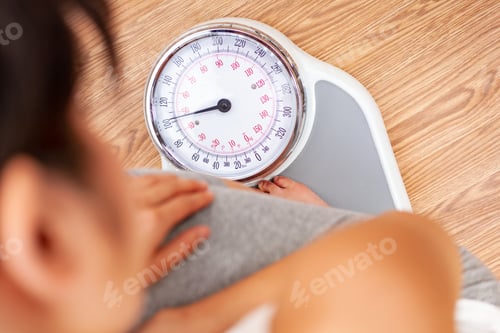Preview: Healthy Female Woman Weighing Herself on Scales