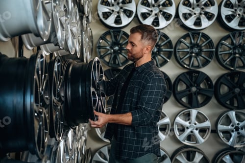 Preview: Choosing the right disk. Man worker is maintenance station with tires, wheels