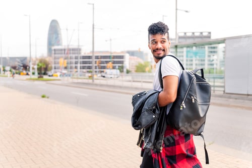 Preview: latin student walking in the city with a backpack