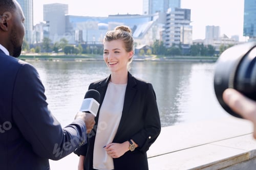 Preview: Young African male reporter with microphone standing in front of successful businesswoman