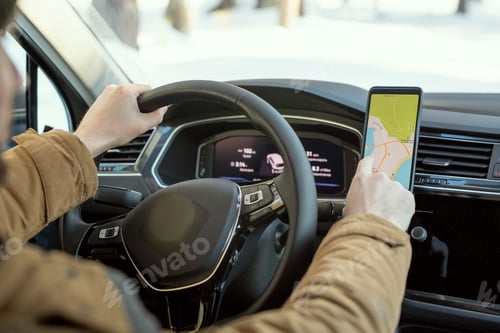 Preview: Hands of young man in warm winterwear holding by steer while using map