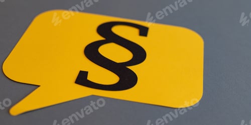 Preview: Selective focus shot of a yellow card with the law paragraph symbol