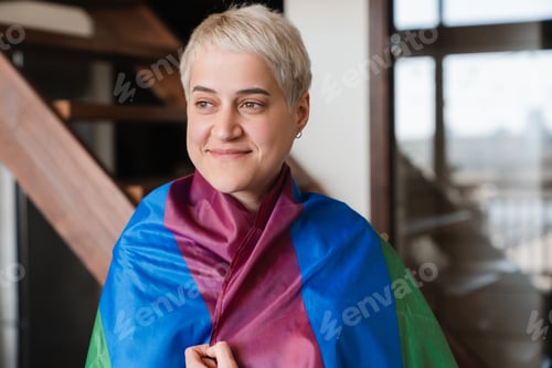 Preview: Young woman hipster with short haircut lesbian female covering with LGBT flag.