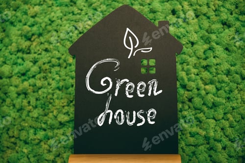 Preview: Green house. Close-up of house shaped blackboard with hand writing text at moss background