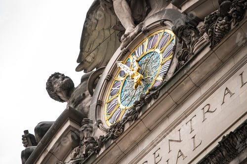 Preview: Old fashioned clock hanging on building