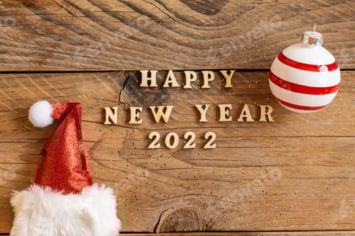 Visualização: Citação de letras de madeira de feliz ano novo de 2022 com chapéu de Papai Noel vermelho cintilante e bugiganga listrada em madeira