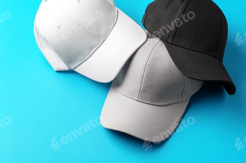 Preview: Baseball caps on blue background studio shot