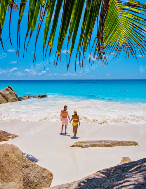 Preview: Anse Georgette Praslin Seychelles, young couple men and woman on a tropical beach during a luxury