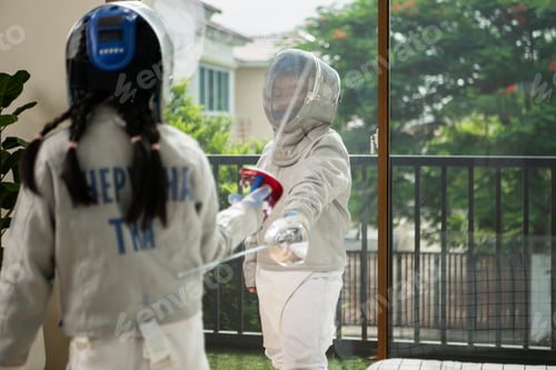 Preview: Before the tournament day, a boy and girl dressed in fencing gear are rehearsing in gym