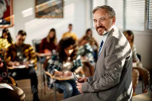 Visualização: Professora madura feliz na sala de aula olhando para a câmera.