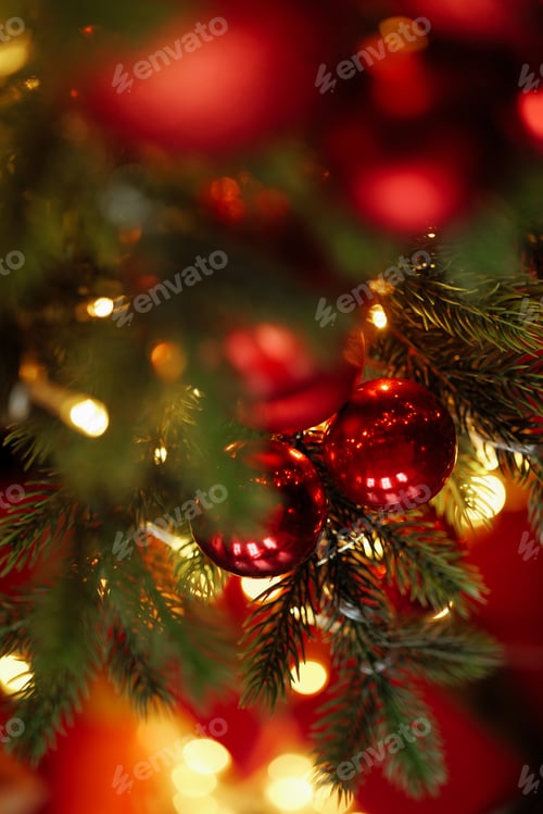 Preview: Close-up of a Christmas tree with red balls and bokeh in the background.