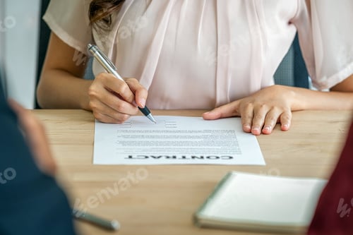 Preview: Closeup Young Asian woman graduate hand signing the contract after deal interview