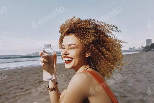 Preview: Sandy Beach Bliss: A Happy Woman Drinking a Refreshing Cold Drink on a Sunny Summer Day