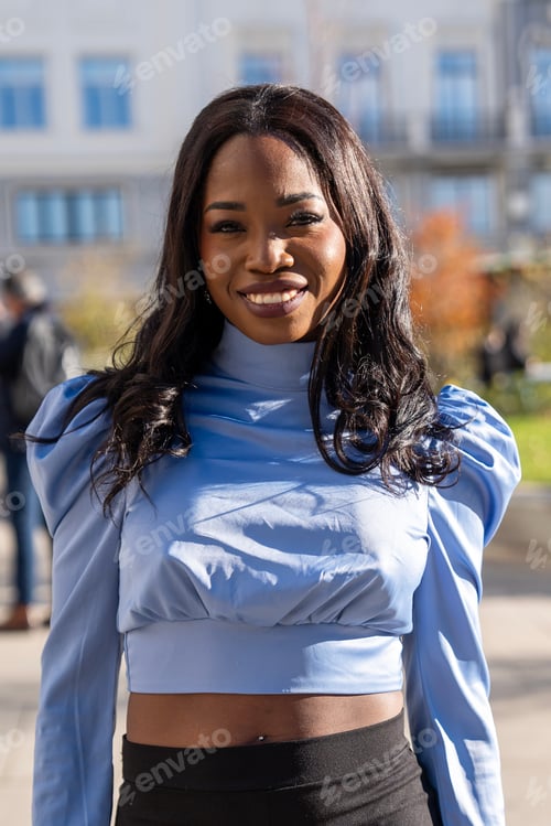 Preview: Portrait of a young african american businesswoman smiling confidently in a city setting