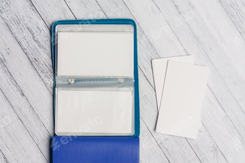 Preview: open business card holder with letterheads on a wooden table top view