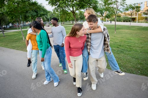 Preview: A large multiracial group of teenagers laughing and having fun piggybacking together