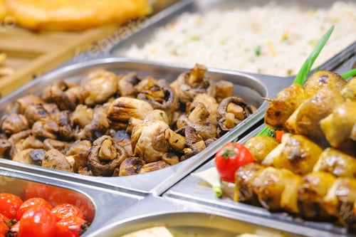 Preview: Delicious grilled mushrooms and flavorful skewers with vibrant fresh tomatoes at a catering buffet.