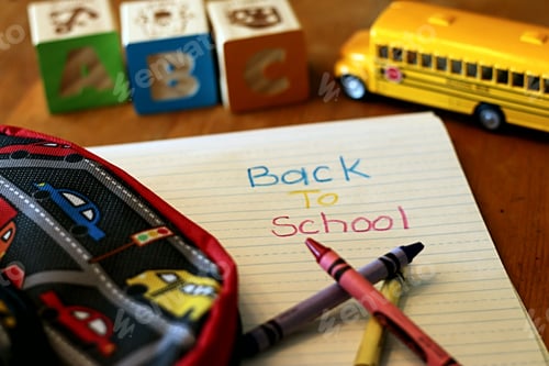 Preview: Conceptual image of school supplies and yellow bus on a tabletop.