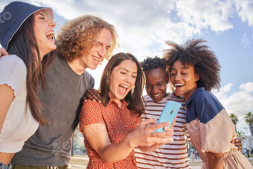 Preview: Group of young people having fun watching something on their cell phones.