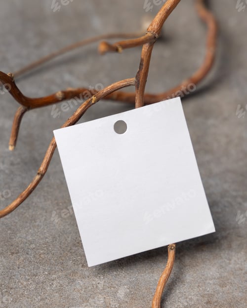 Preview: Blank square gift tag mockup on grey stone with dry branches, copy space. Handmade product label